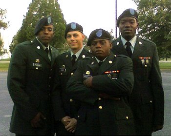 Four army soldiers in dress uniform posing together