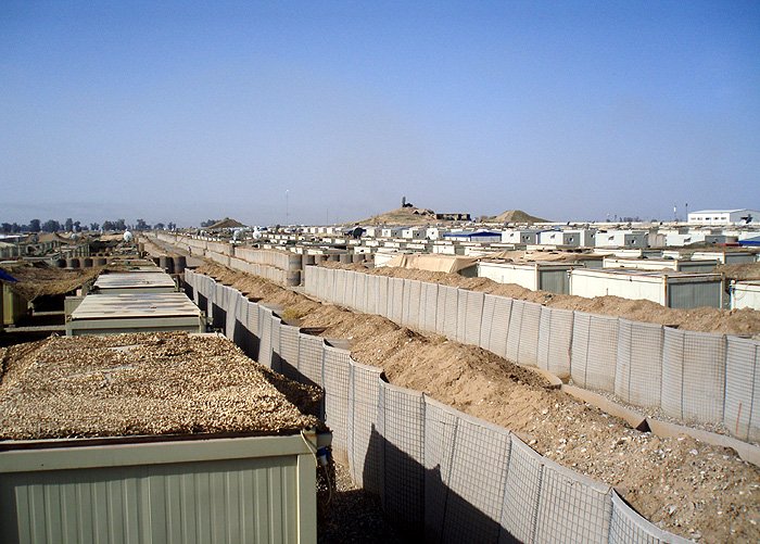Military housing containers lined up in desert base setting