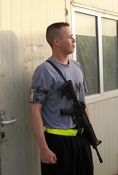 Daniel Kekipi carrying rifle on arm while on duty in Iraq