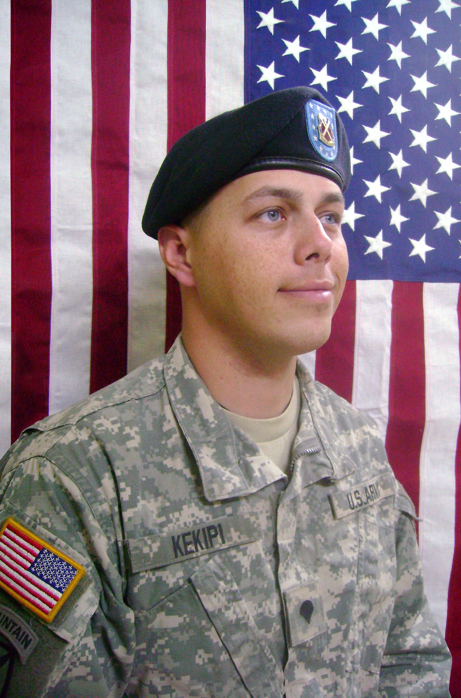 Official portrait of Daniel Kekipi in uniform in front of American flag