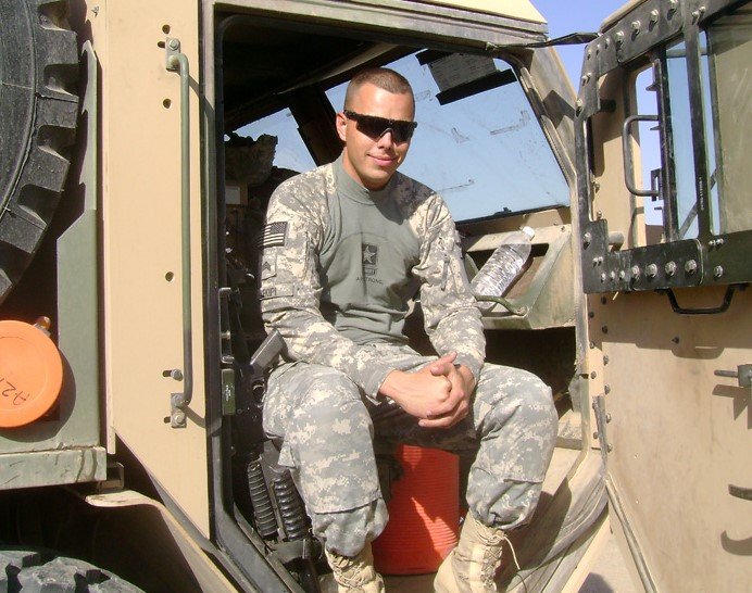 Daniel Kekipi sitting in open door of armored tactical vehicle