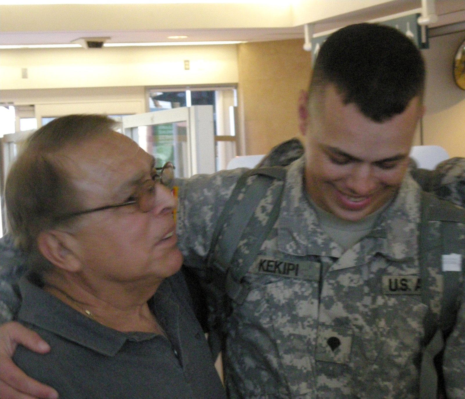 Daniel Kekipi hugging his grandfather at airport arrival terminal