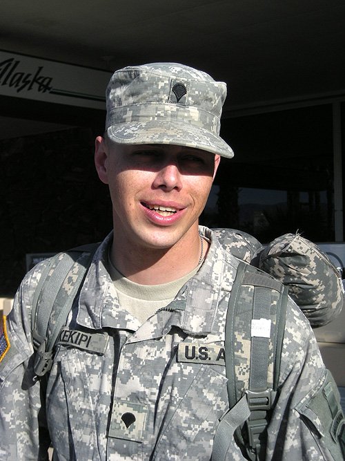 Daniel Kekipi smiling with backpack after returning home from deployment