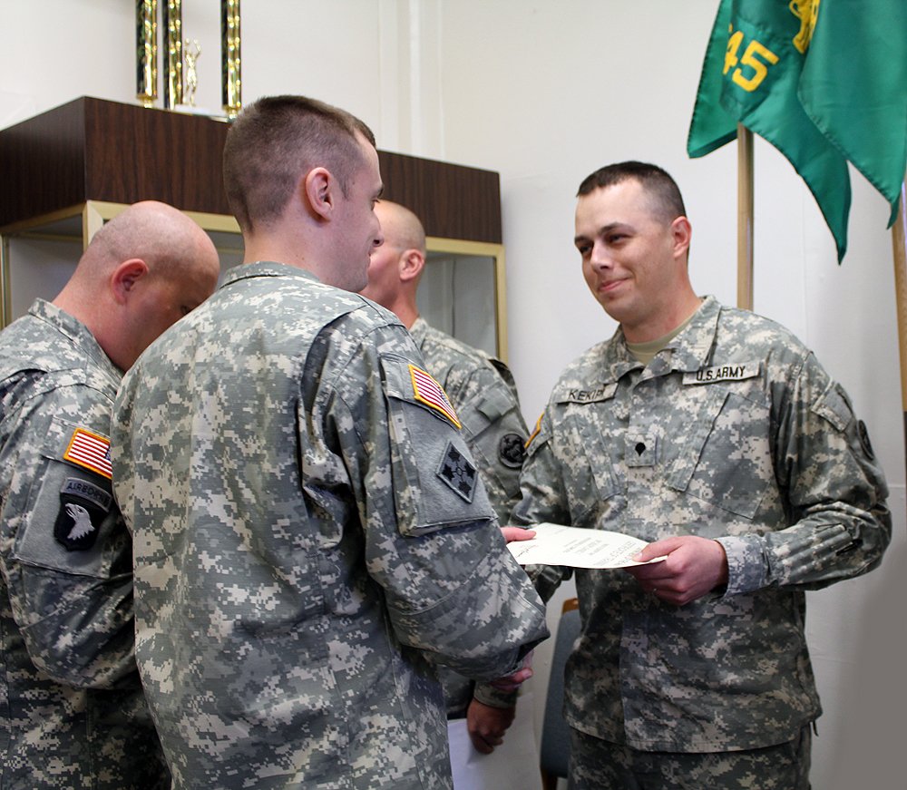Daniel Kekipi receiving award certificate from officer during military police ceremony